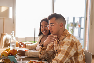 Couple using smart phone at dining table
