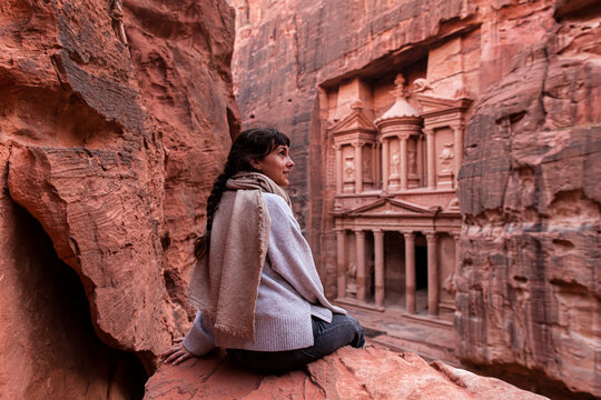 Woman sitting in front of Al-Khazneh treasury, Petra, Jordan