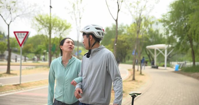 남편의 팔짱을 끼고 걸으며 대화하는 부부 