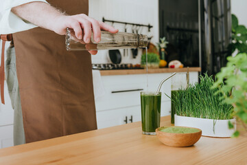 Man pouring water in detox juice in kitchen at home