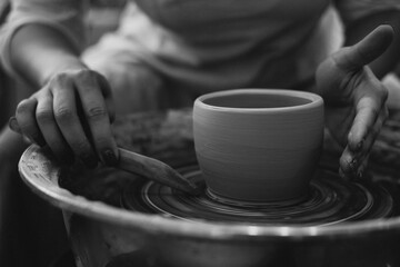 Fototapeta na wymiar Woman working on pottery wheel creating a bowl