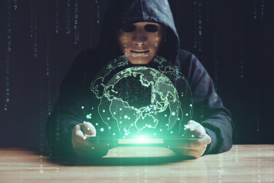 Black hat hacker using tablet on table sensitive data cyber crime hack in black dark room green earth hologram background matrix binary code. Cyber security cyber crime concept. Hacking phishing