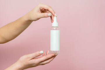 Cosmetic bottle in woman's hands. Cosmetic product branding mockup. Spa beauty treatment concept
