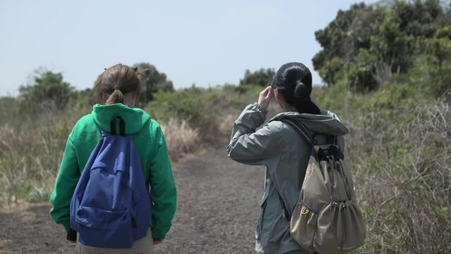 친구와 함께 제주도 오름을 걸으며 산책하는 모습 