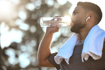 Man, fitness and drinking water in nature for sustainability, hydration or break after running...