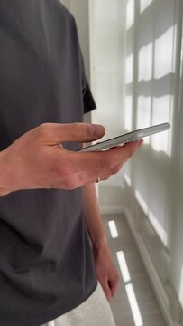 Close up view of male hands using smartphone scrolling, browsing, surfing internet, social media browsing slow motion