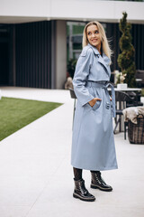 Young woman in blue coat walking in the city