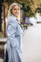 Fototapeta premium Woman in blue coat walking in park