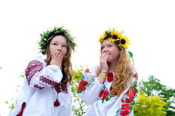 beautiful young teenage girl in wreath for Ukrainian holiday with friend communicate place for advertising text ukrainian tradition put a wreath on her head weave braids embroidered shirts