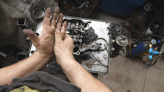 POV male dirty hands of young mechanic at workshop. Repairman rubbing unclean arms from fuel oil after hard work at garage. Concept of maintenance service. Slow motion