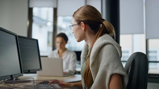 It woman programming code in office. Casual software developer typing computer