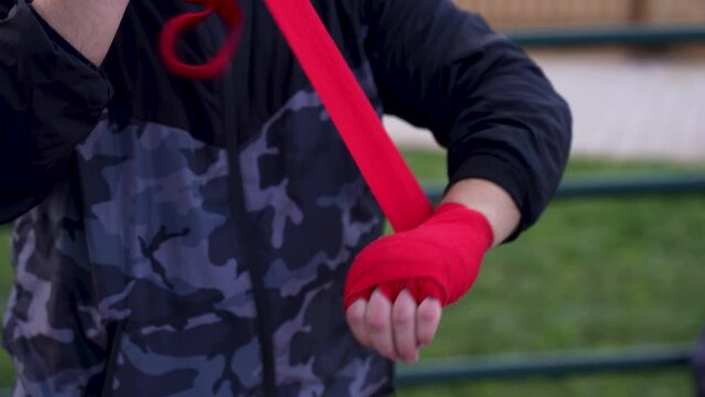Focused Training: Athletes Wrap Hands for Morning Shadowboxing on Palm-Adorned Basketball Court