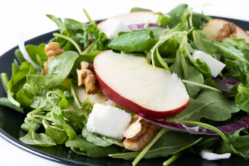 Autumn salad with apples and walnuts isolated on white background. Close up