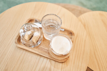 Coffee with milk, a cookie and a glass with water on a wooden table. Cup of coffee cappuccino with...