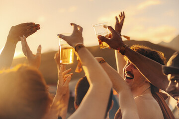Crowd of people dancing and celebrating with drinks at a music festival