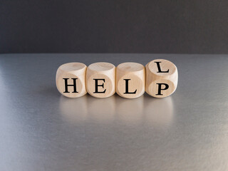 Hell or help symbol. Turned a cube and changes the word 'hell' to 'help'. Business, psychology and hell or help concept. Beautiful black background, gray table, copy space.