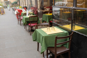 Street view with cafe terrace during the morning in city, Italy. Empty tables in between dining hours