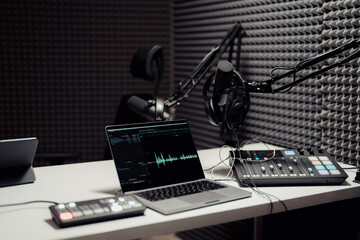 Equipment for podcast recording in studio. Modern laptop connected to mixing consoles and...