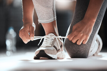 Hands, shoelaces and floor at gym with woman, fitness and ready for workout, wellness or training. Girl, sport shoes or sneakers for exercise, performance or health for lifestyle, motivation and club