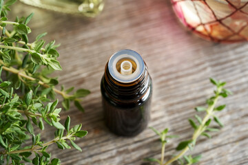 A bottle of aromatherapy essential oil with thyme twigs