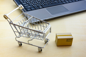 Online shopping and goods delivery service, ecommerce concept : Shopping cart, a box and a laptop...