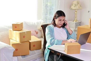 Fototapeta na wymiar Attractive happy asian pregnant woman sitting and using mobile smart phone and writing order for customer with tablet. Expectant mother preparing and working for baby birth during pregnancy concept.