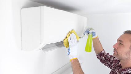Service guy cleaning and maintaining air condition unit.