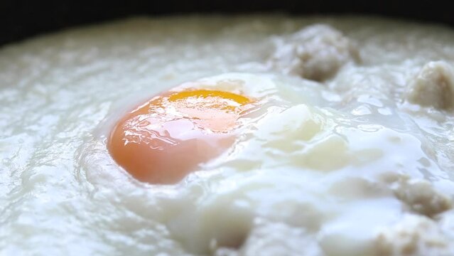 Close up of congee or rice porridge with pork and soft boiled egg, Chinese food