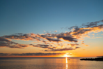 Idyllic view of ocean sunset. Reflection of golden sundown on the sea water. Relax seascape with copy space. Concept of summer, travel and calmness