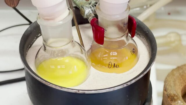 Colourful reactions under heating condition in sand bath. 4K video experiments in a chemistry lab. Biochemical medicine synthesis in the laboratory.