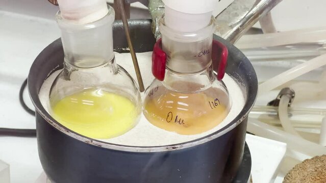 Colourful reactions under heating condition in sand bath. 4K video experiments in a chemistry lab. Biochemical medicine synthesis in the laboratory.
