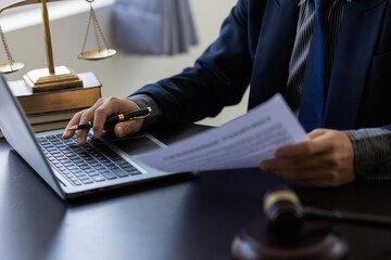 Lawyer's office. Justice with scales and judge hammer at lawyer working on laptop legal documents...