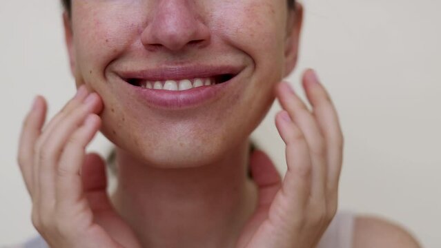 millennial woman doing face procedures,applying under eye patches,vitamin c serum or sheet facial mask.female girl with towel on head having fun,cover mouth with blanket or book.face through palms