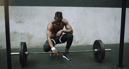 Fototapeta na wymiar Weightlifting, bodybuilder and black man with barbell in gym for training, exercise and strong workout. Fitness, muscles and male person lifting weights for challenge, wellness and body strength