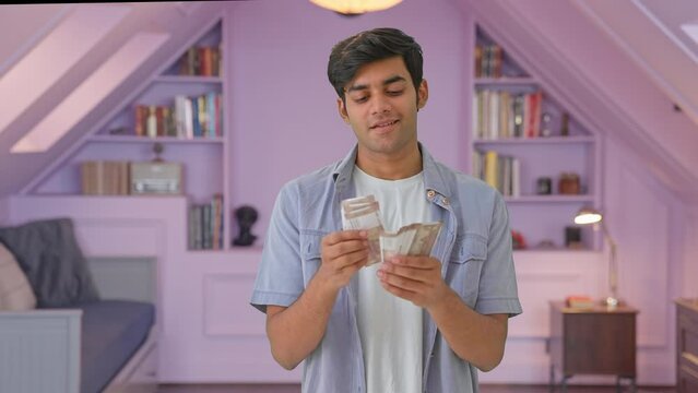 Happy Indian young man counting money