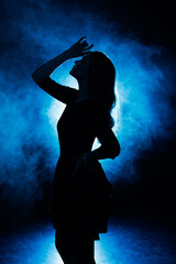 Silhouette of a girl in smoke on a blue background.