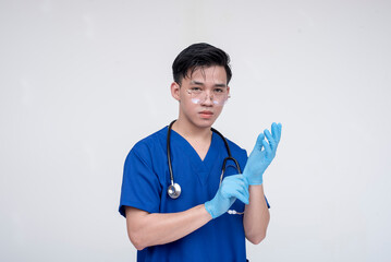 Portrait of a young and skilled medical student, nurse, intern fixing his gloves while looking at...