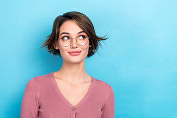 Photo of cute dreamy woman dressed pink shirt eyewear looking empty space isolated blue color background