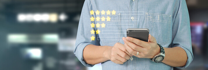 Man holding smartphone device and touching screen with five star rating feedback