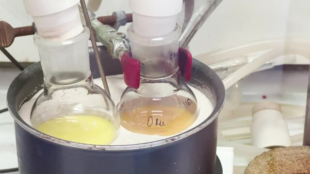 Colourful reactions under heating condition in sand bath. 4K video experiments in a chemistry lab. Biochemical medicine synthesis in the laboratory.