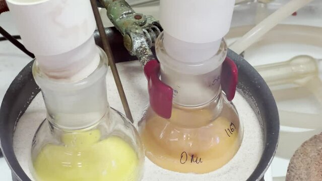 Colourful reactions under heating condition in sand bath. 4K video experiments in a chemistry lab. Biochemical medicine synthesis in the laboratory.