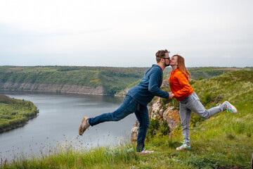 Naklejka na ściany i meble Happy in love romantic cheerful couple man and woman hug and kiss. the summer mountains adventure enjoy the local nature. Dniester river canyon, Subich, Ukraine