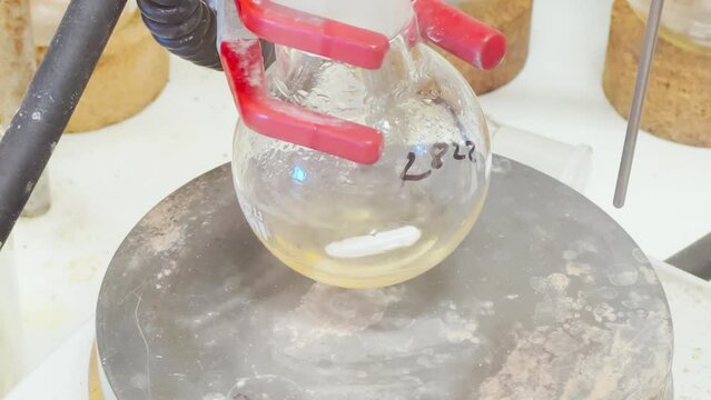 Colourful reactions under heating condition in sand bath. 4K video experiments in a chemistry lab. Biochemical medicine synthesis in the laboratory.
