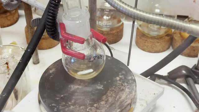 Colourful reactions under heating condition in sand bath. 4K video experiments in a chemistry lab. Biochemical medicine synthesis in the laboratory.