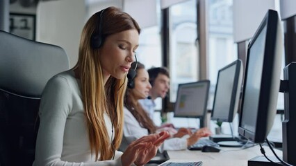 Support service agent talking in call center. Positive woman typing computer