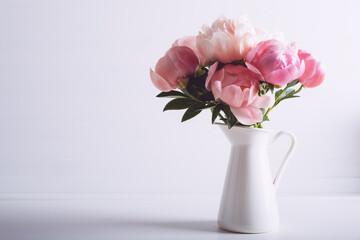 Beautiful bouquet of fresh coral peony flowers in full bloom in vase. Floral still life with...