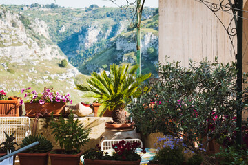 Fototapeta na wymiar Cozy table, chairs and flowers in a garden with beautiful panoramic view in Sassi Matera Basilicata Italy