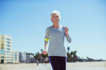 Senior woman power walking on beach