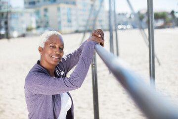 Portrait of confident woman leaning on bar at beach playground
