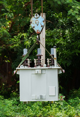 Crane hook lifts up distribution transformer